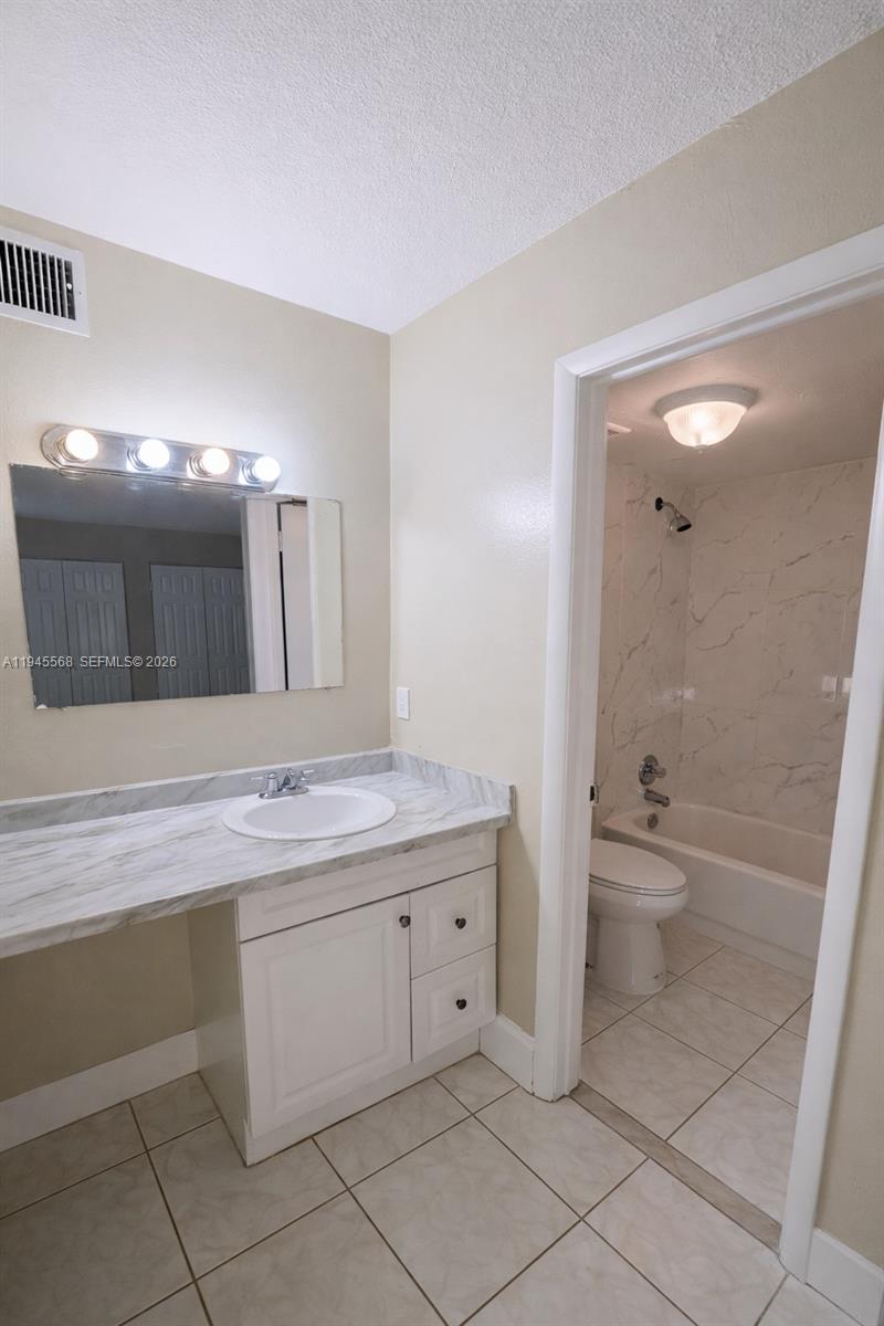 19791 Southwest 114th Avenue, Unit 131 Miami, FL 33157 - Photo 9 of 12 a bathroom with a double vanity sink toilet and a mirror