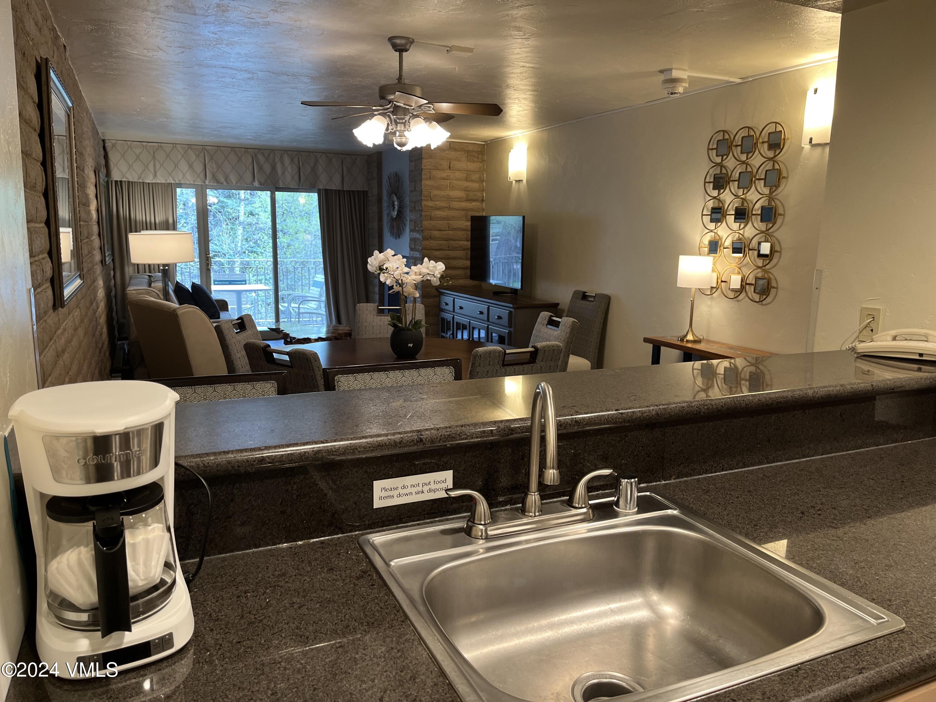1020 Vail View Drive, Unit 221220 Vail, CO 81657 - Photo 3 of 22 a kitchen with a table chairs and couches
