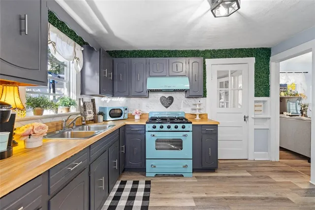 a kitchen with stainless steel appliances granite countertop a sink stove and cabinets