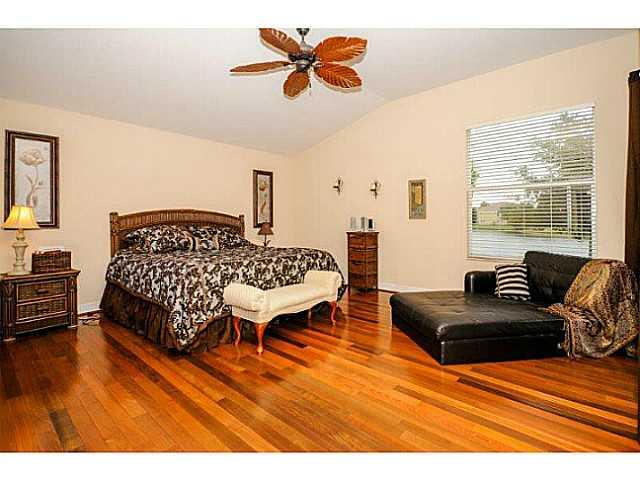 2183 Southwest Panther Trace Stuart, FL 34997 - Photo 13 of 25 a bedroom with a bed and wooden floor