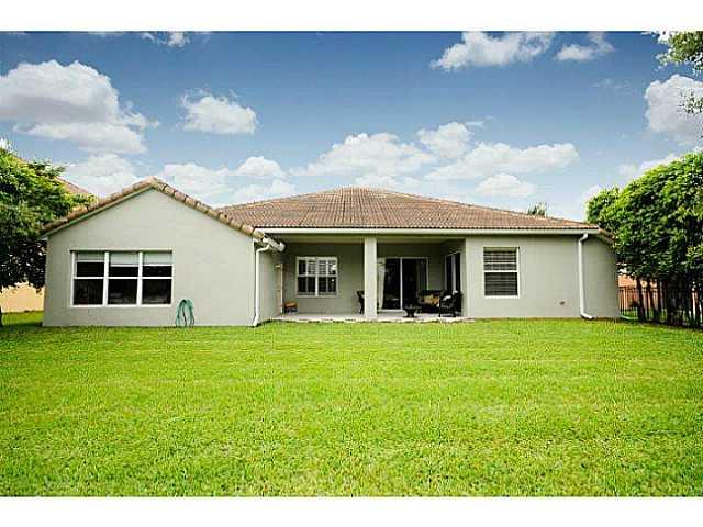 2183 Southwest Panther Trace Stuart, FL 34997 - Photo 23 of 25 a front view of a house with a garden