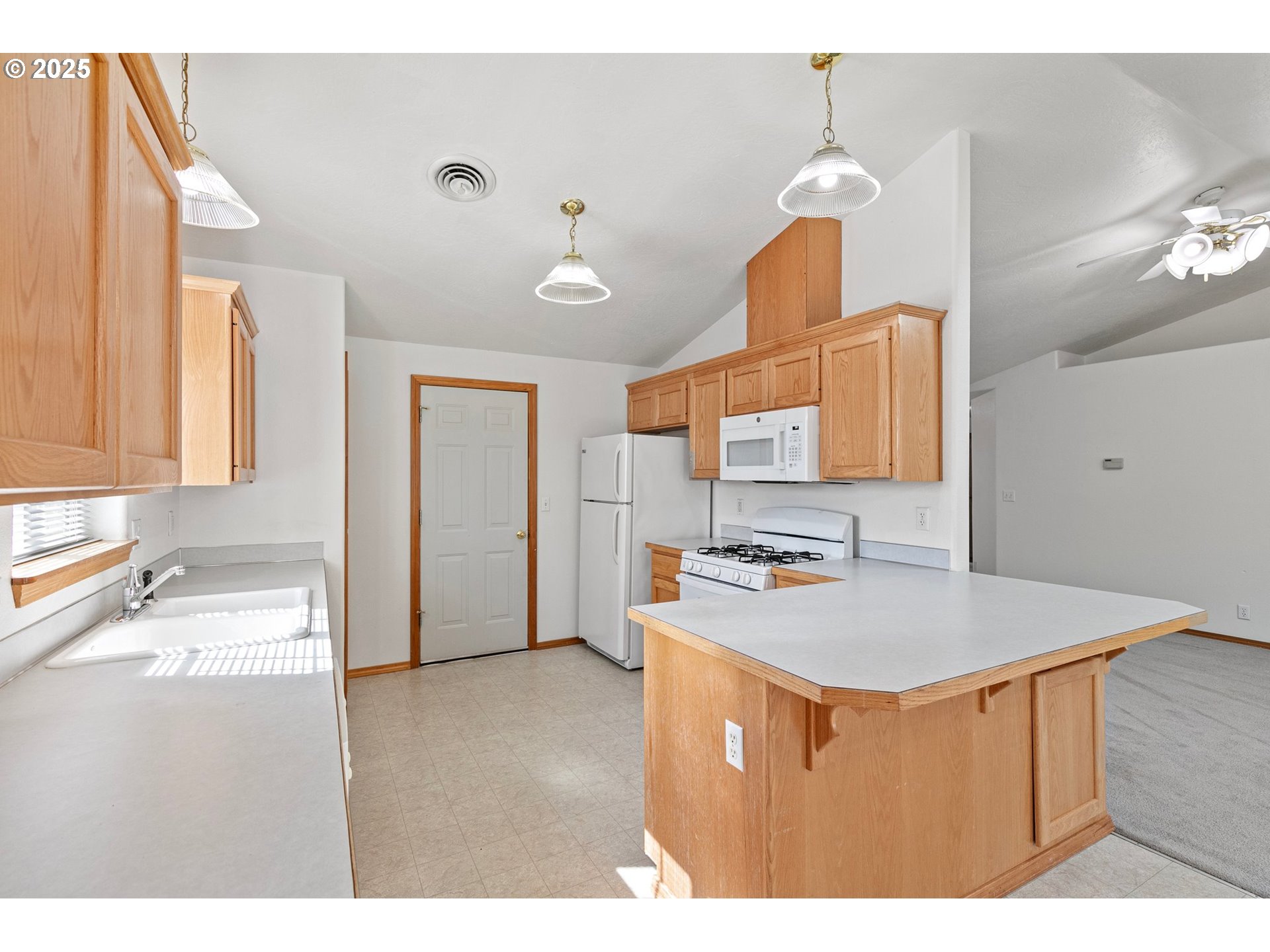 4018 Forsythia Street Springfield, OR 97478 - Photo 15 of 39 a kitchen that has a sink a stove and a table