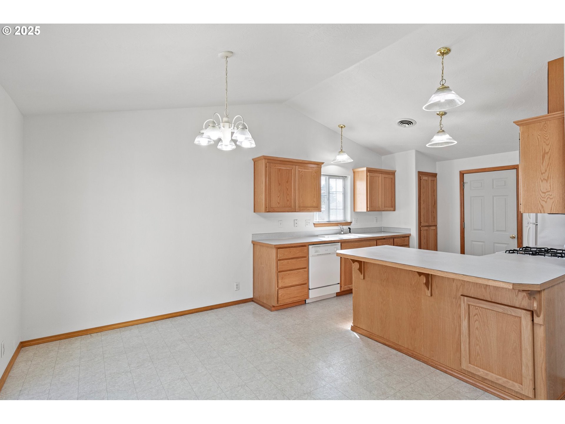 4018 Forsythia Street Springfield, OR 97478 - Photo 10 of 39 a large white kitchen with a dishwasher a stove a sink dishwasher with a dining table and chairs