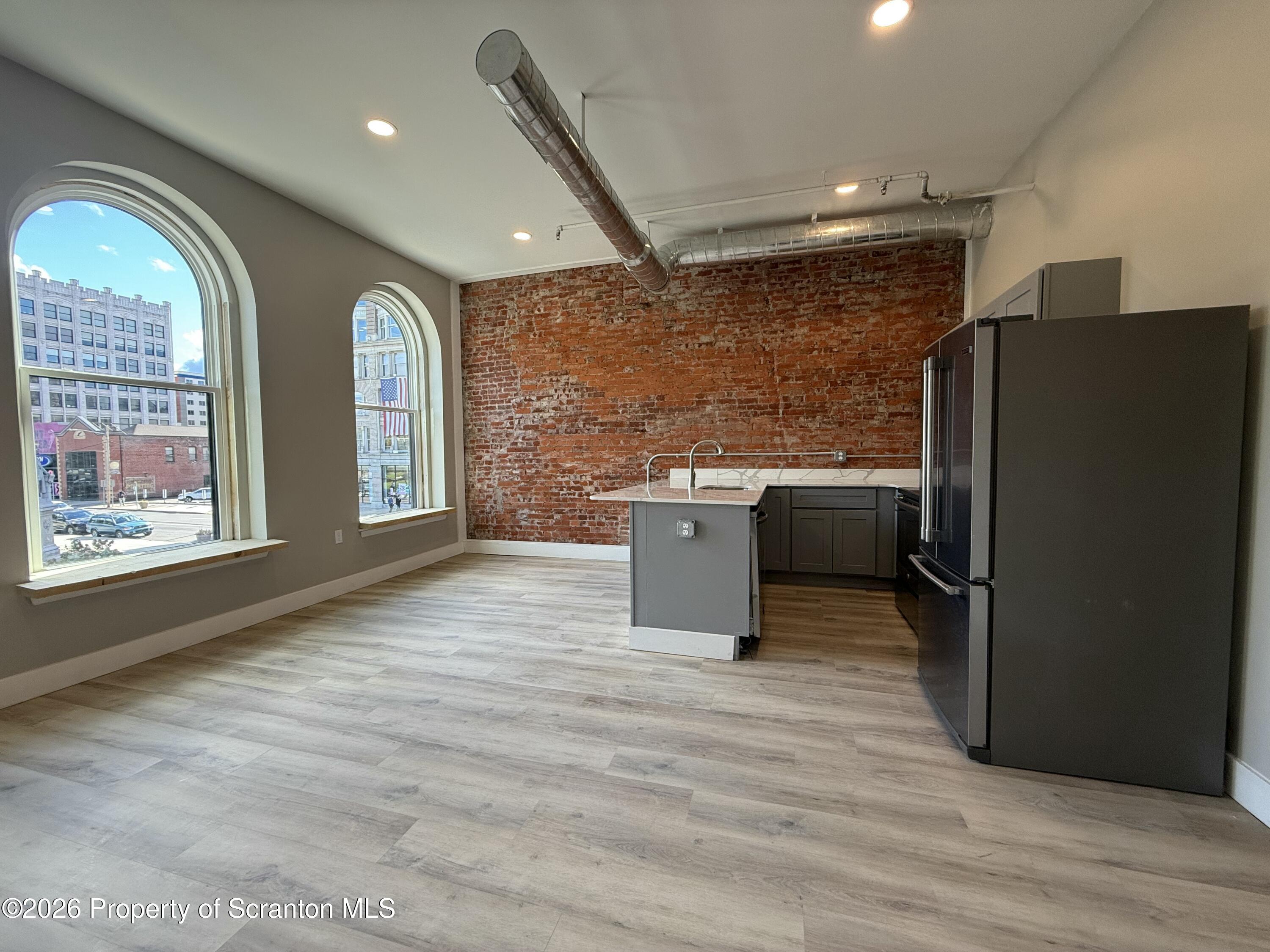 a kitchen with stainless steel appliances granite countertop a refrigerator a sink a stove and island