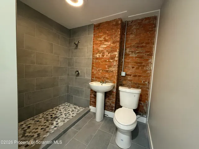 a white toilet sitting next to a bathroom sink