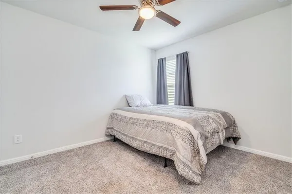 a bedroom with a bed and a ceiling fan