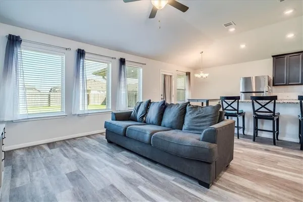 a living room with furniture and a wooden floor