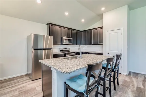 a kitchen with kitchen island a refrigerator stove microwave and cabinets