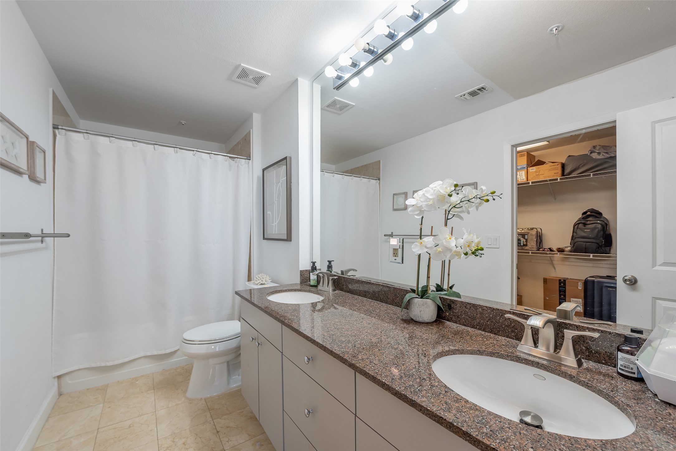 3505 Sage Road, Unit 2210 Houston, TX 77056 - Photo 19 of 40 The ensuite bath features dual sinks, granite counters, abundant cabinets, a luxurious soaking tub, and a shower combo, creating a spa-like retreat within the primary suite.
