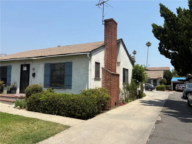 a front view of a house with a yard and potted plants