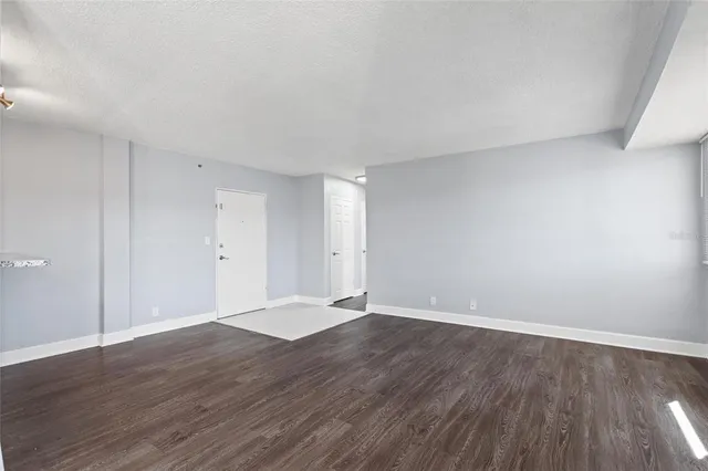 a view of an empty room with wooden floor