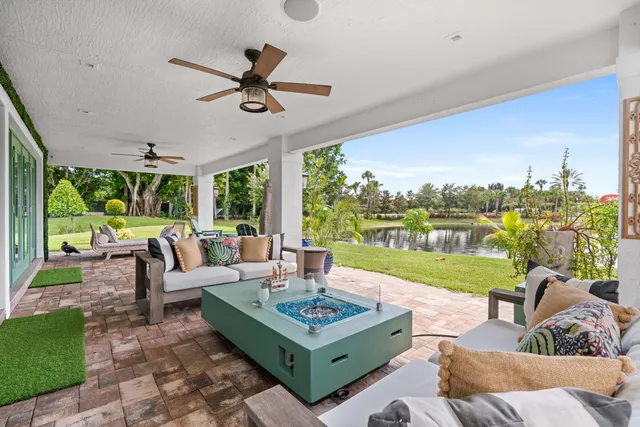 a view of a table and chairs with wooden floor and lake view