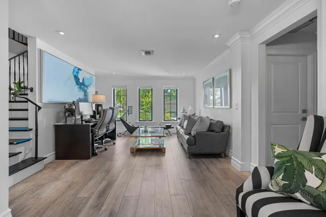 a living room with furniture and hard wood flooring