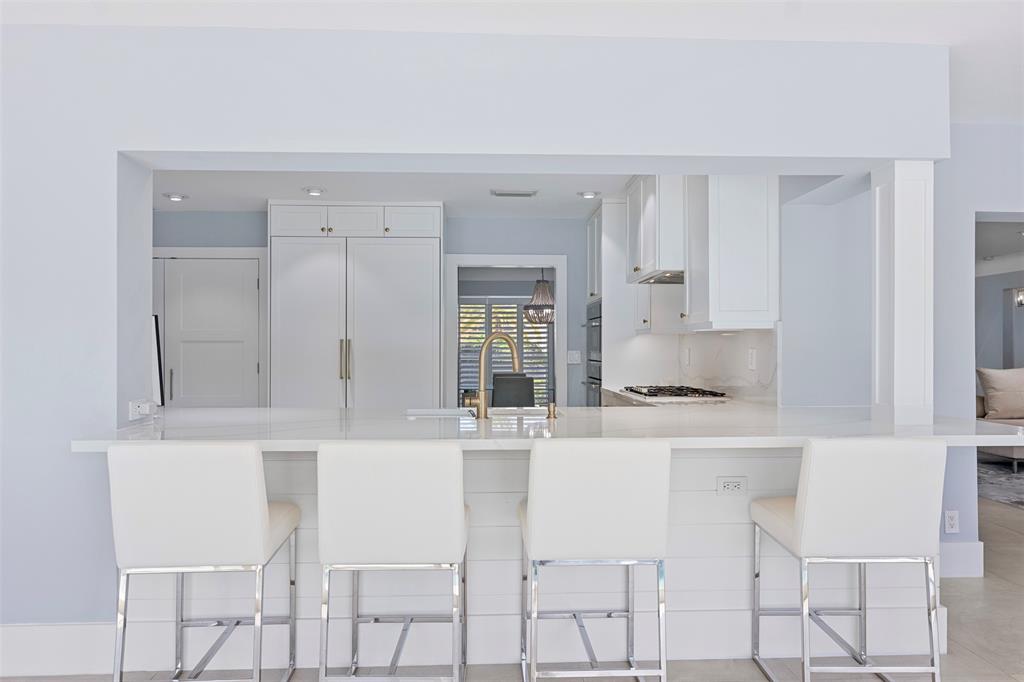 2330 Northeast 35th Street Lighthouse Point, FL 33064 - Photo 12 of 71 a kitchen with granite countertop white cabinets and white appliances