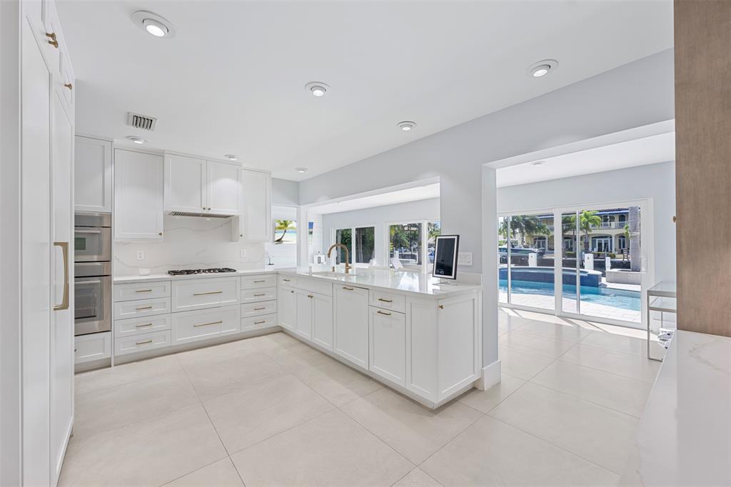2330 Northeast 35th Street Lighthouse Point, FL 33064 - Photo 13 of 71 a large white kitchen with white cabinets and a stove