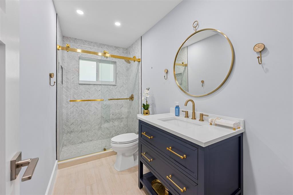 2330 Northeast 35th Street Lighthouse Point, FL 33064 - Photo 26 of 71 a bathroom with a sink a toilet and a mirror