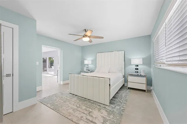 a view of a white house with a yard and potted plants