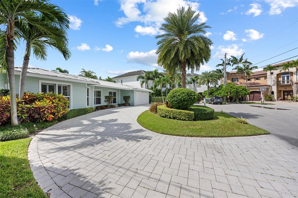 2330 Northeast 35th Street Lighthouse Point, FL 33064 - Photo 39 of 71 a view of a white house with a yard and potted plants