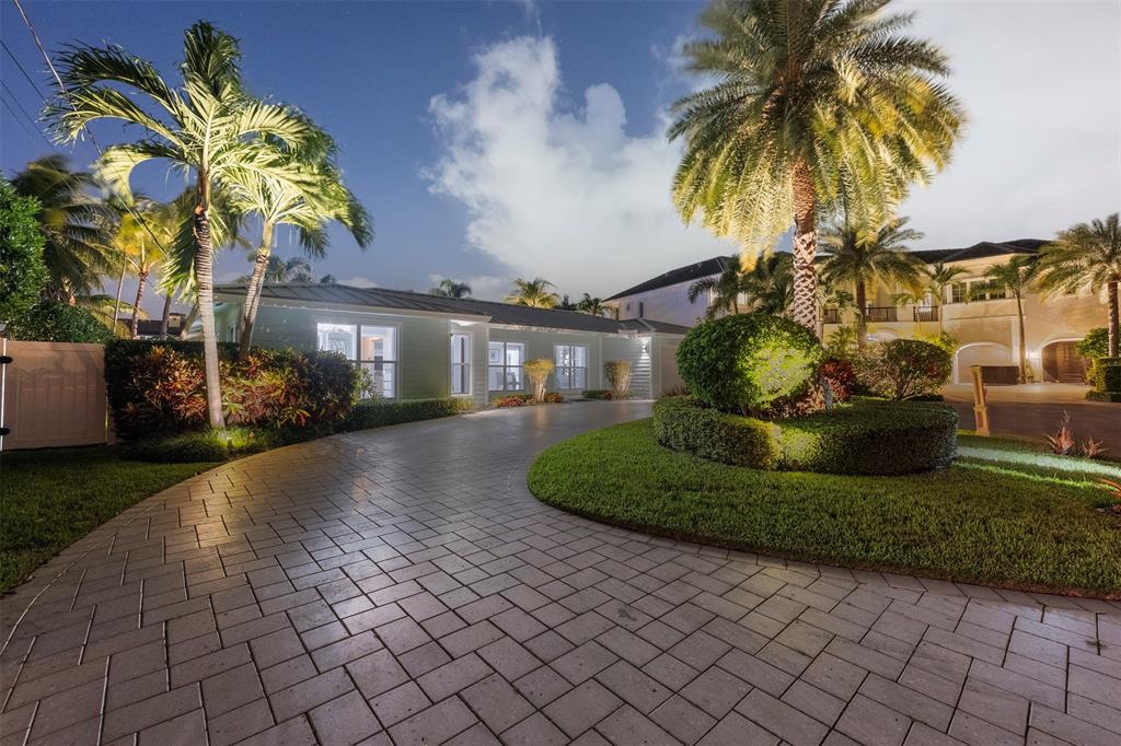 2330 Northeast 35th Street Lighthouse Point, FL 33064 - Photo 40 of 71 a front view of a house with fountain and a garden