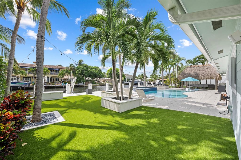 2330 Northeast 35th Street Lighthouse Point, FL 33064 - Photo 58 of 71 a view of a swimming pool with a garden and patio