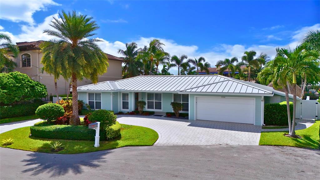 2330 Northeast 35th Street Lighthouse Point, FL 33064 - Photo 6 of 71 a front view of a house with a yard and garage
