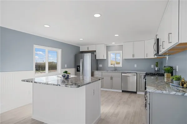 a kitchen with stainless steel appliances granite countertop a sink stove and refrigerator