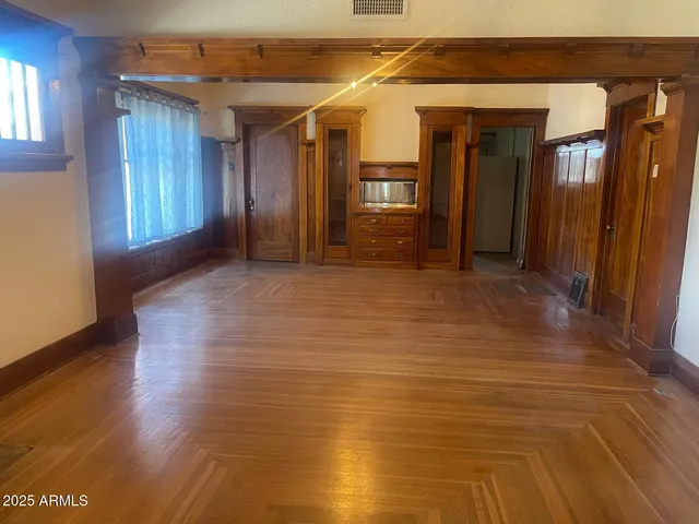 a view of hallway with window and wooden floor