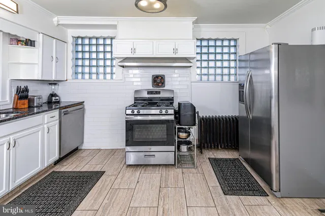 a kitchen with granite countertop a refrigerator and a stove