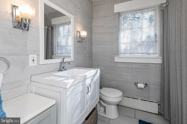 a bathroom with a toilet sink vanity and mirror