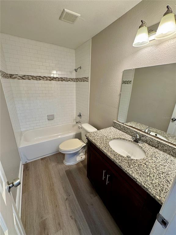 1912 West Grace Street Tampa, FL 33607 - Photo 13 of 22 a bathroom with a granite countertop sink a toilet a mirror and shower