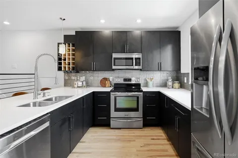 a kitchen with stainless steel appliances a sink stove and refrigerator