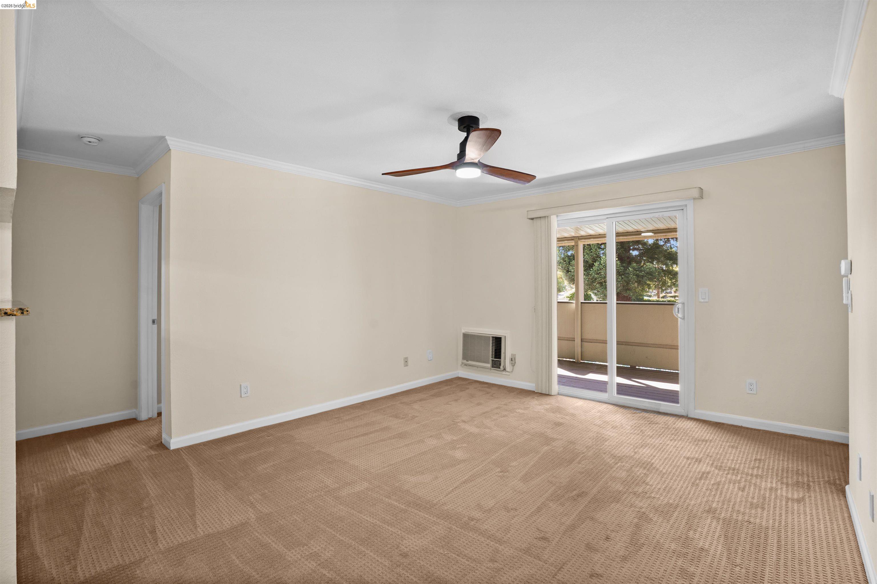 1505 Kirker Pass Road, Unit 214 Concord, CA 94521 - Photo 23 of 55 Carpeted interior space featuring a ceiling fan with integrated lighting, crown molding, and an in-wall air conditioning unit