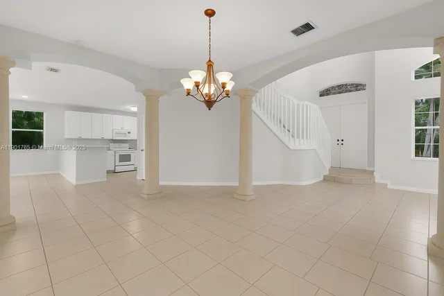 a view of a livingroom with a chandelier furniture and windows