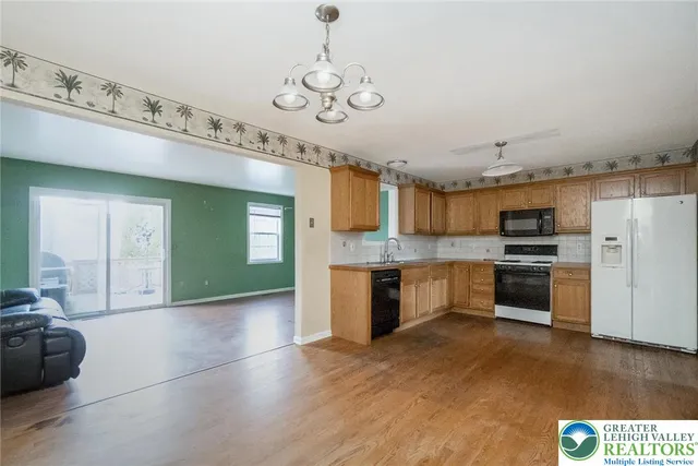 a large kitchen with stainless steel appliances granite countertop a stove and cabinets