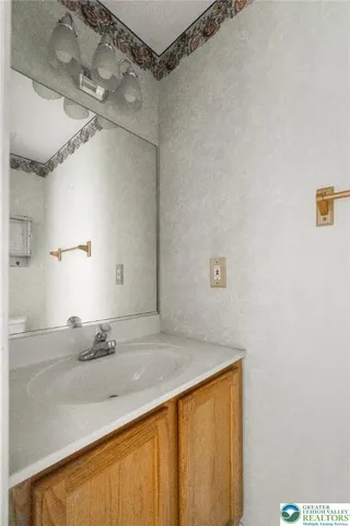 a bathroom with a granite countertop sink and white cabinets