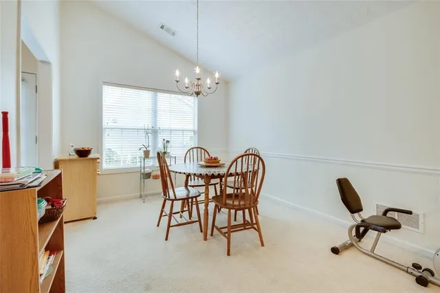 a view of a dining room with furniture and chandelier