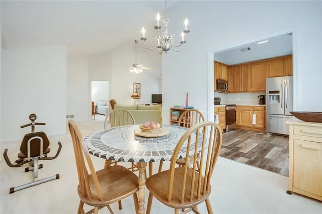 a kitchen with a refrigerator a stove top oven a sink dishwasher and wooden cabinets with wooden floor