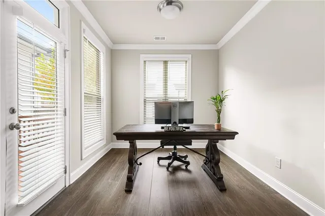 a view of a workspace with furniture and a window