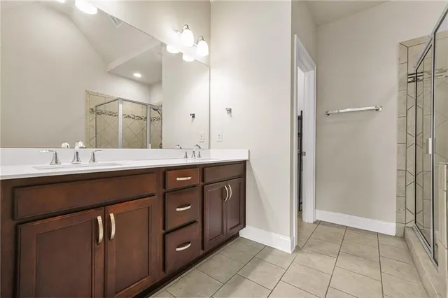 a bathroom with a double vanity sink a mirror and a shower