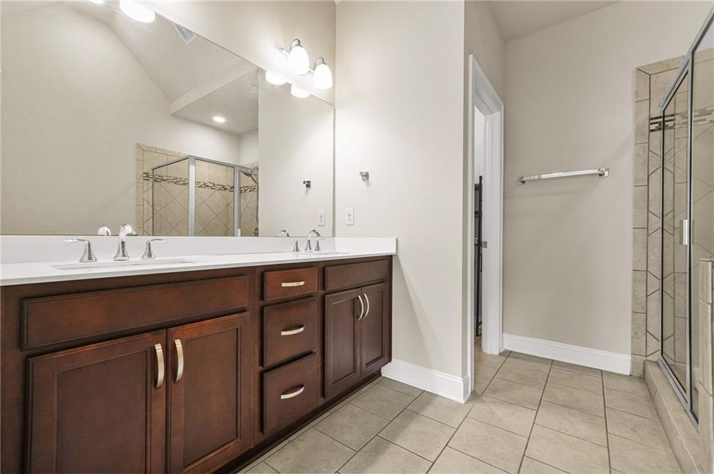 2207 Parkside Gln View Duluth, GA 30097 - Photo 20 of 41 a bathroom with a double vanity sink a mirror and a shower