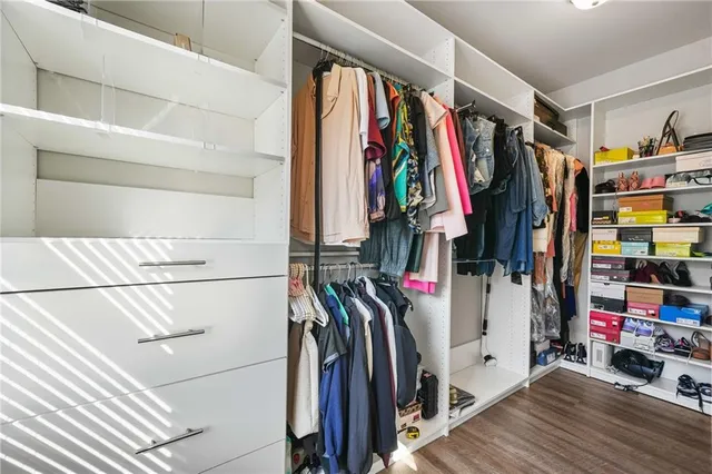 a view of walk in closet with clothes and shoes