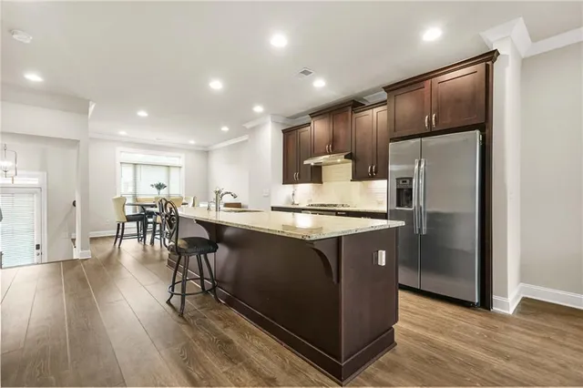 a kitchen with stainless steel appliances granite countertop a refrigerator a sink and a stove