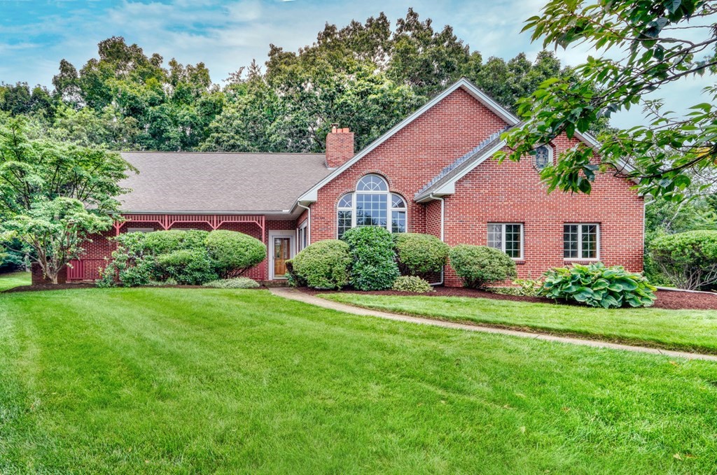 a front view of a house with a yard and trees