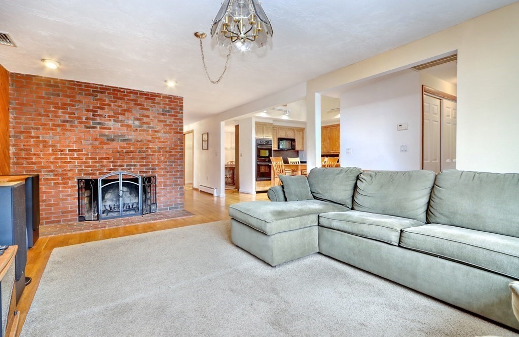 11 Viking Road Winchester, MA 01890 - Photo 3 of 41 a living room with furniture a fireplace and a chandelier