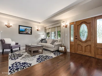 a living room with furniture a clock on wall and a window