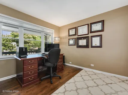 a view of a workspace with furniture and a window