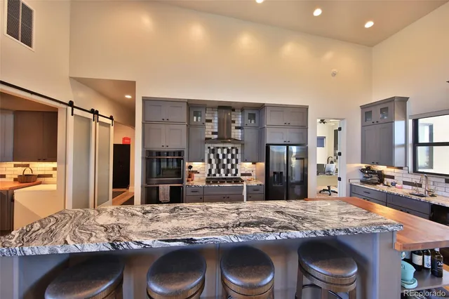 a kitchen with stainless steel appliances granite countertop a stove refrigerator and cabinets