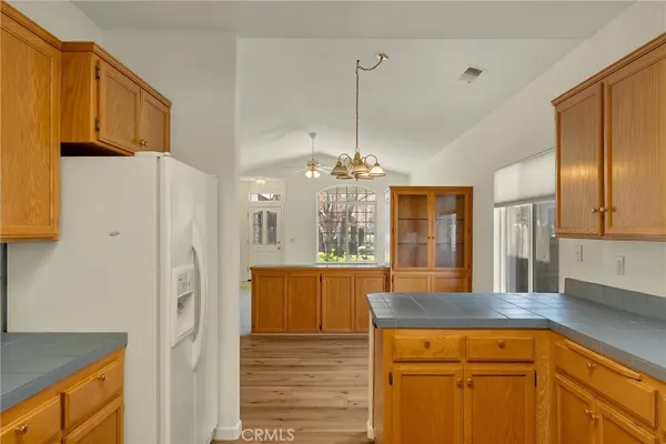 a kitchen with stainless steel appliances granite countertop a refrigerator a sink dishwasher stove and oven with wooden cabinets