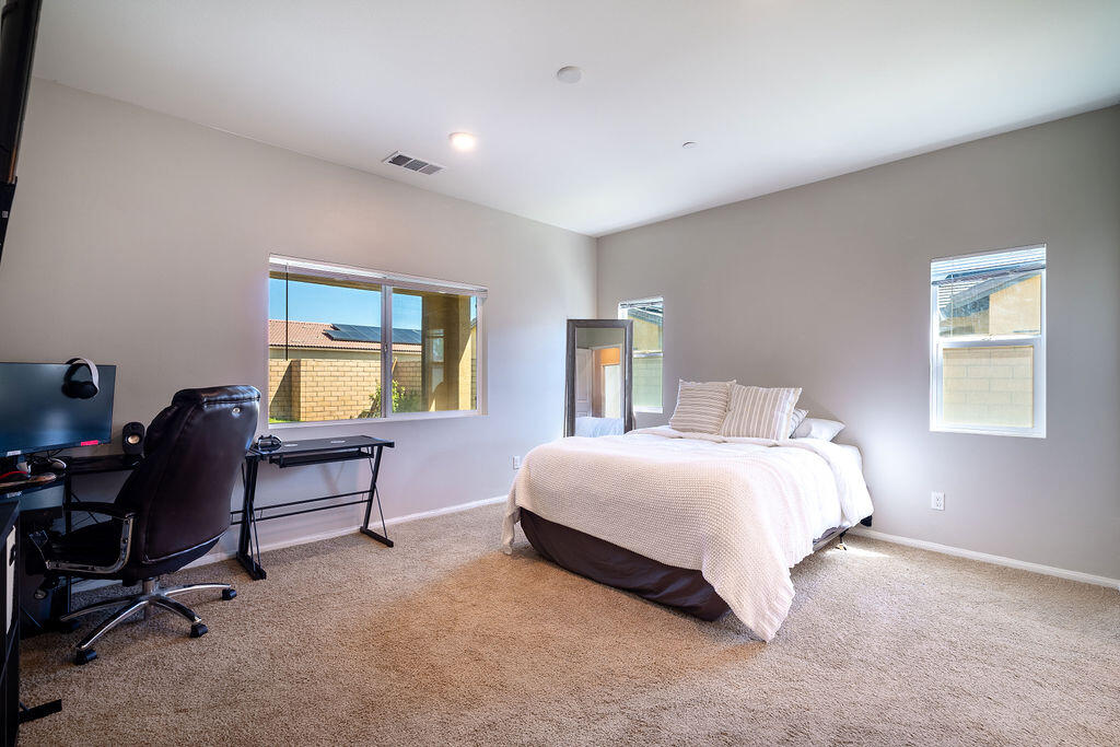 67470 Rio Naches Road Cathedral City, CA 92234 - Photo 11 of 32 a bedroom with a bed a desk and chair