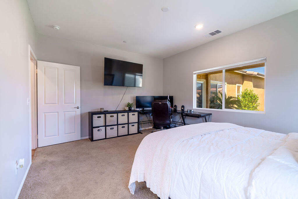 67470 Rio Naches Road Cathedral City, CA 92234 - Photo 12 of 32 a spacious bedroom with a bed and a flat screen tv